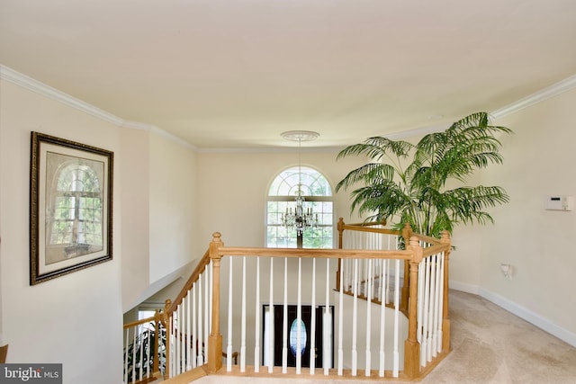 staircase featuring ornamental molding, carpet floors, and an inviting chandelier