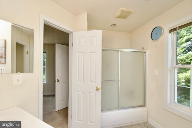 bathroom with bath / shower combo with glass door