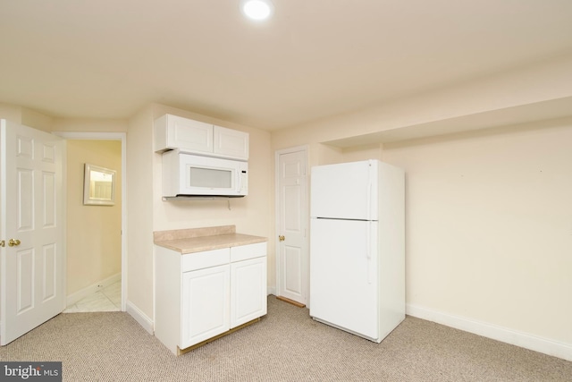 kitchen with light carpet, white cabinetry, and white appliances