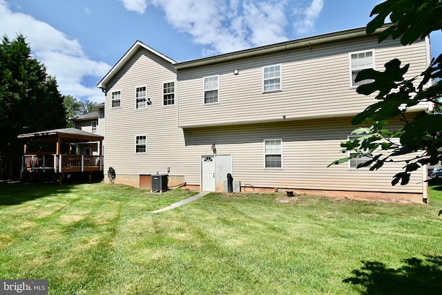 rear view of house featuring a wooden deck, a yard, and cooling unit