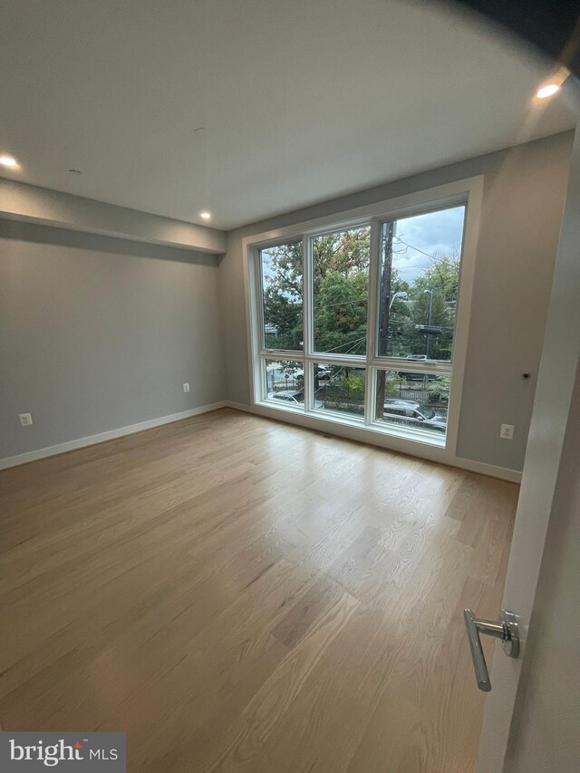 unfurnished room with wood-type flooring