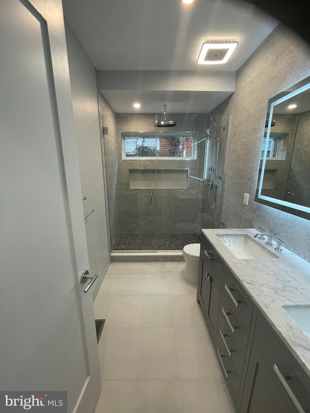 bathroom with tile patterned flooring, vanity, toilet, and an enclosed shower