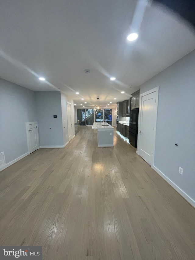 unfurnished living room with hardwood / wood-style flooring and sink