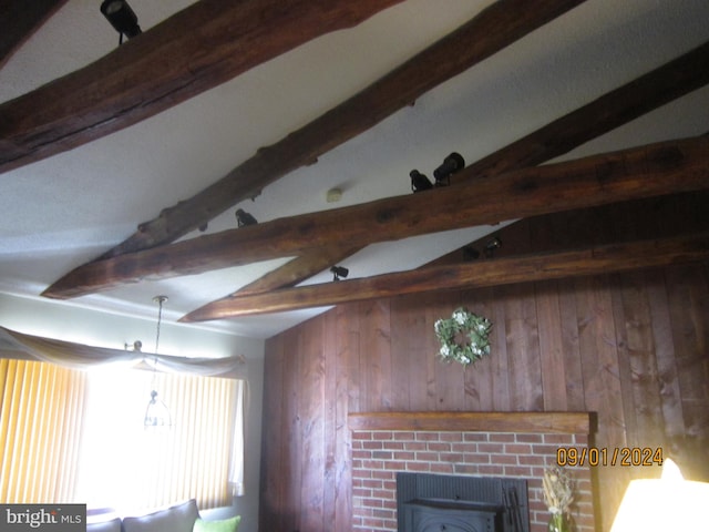 interior details featuring wood walls, beamed ceiling, and a fireplace