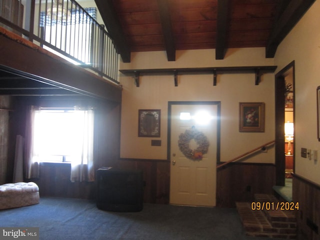 living room with wood ceiling, wood walls, carpet floors, and beam ceiling