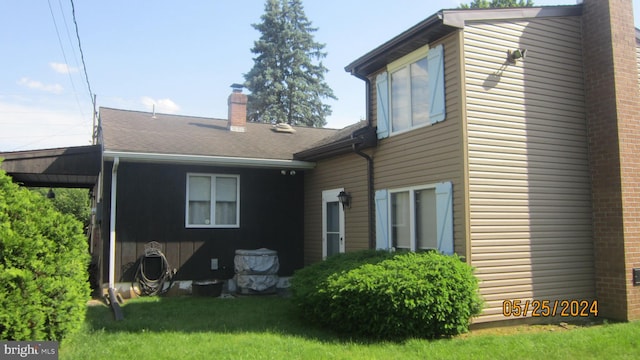 rear view of property featuring a lawn