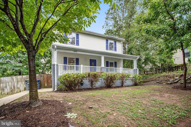 traditional-style house with fence and covered porch