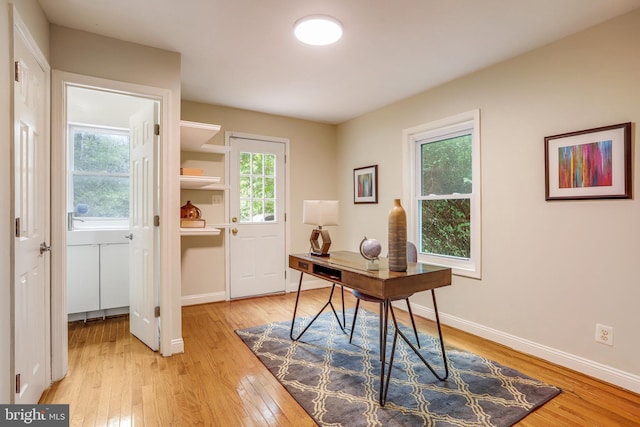 home office with light hardwood / wood-style floors