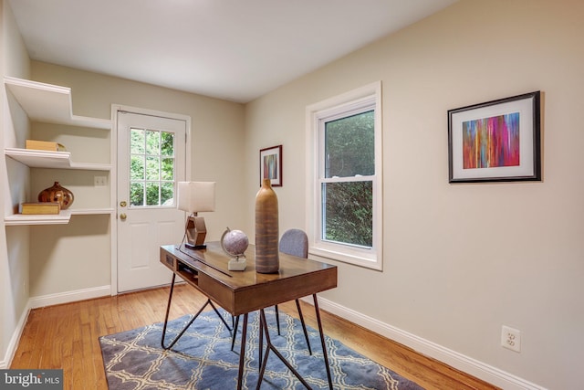 home office with a healthy amount of sunlight and light hardwood / wood-style floors