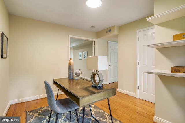 home office with light hardwood / wood-style flooring