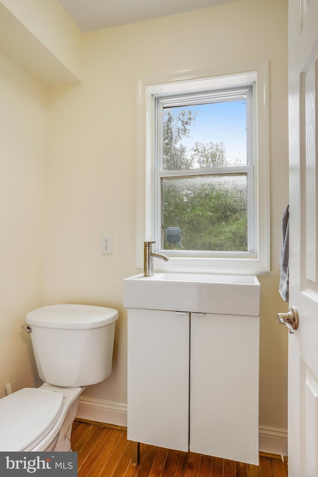 bathroom featuring wood-type flooring, toilet, and plenty of natural light