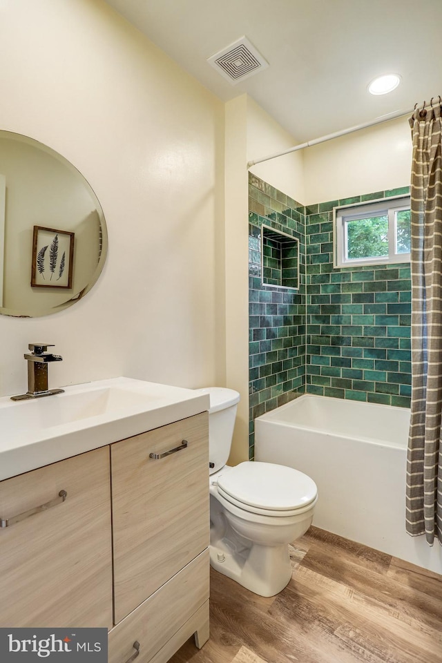 full bathroom with vanity, toilet, hardwood / wood-style flooring, and shower / tub combo with curtain