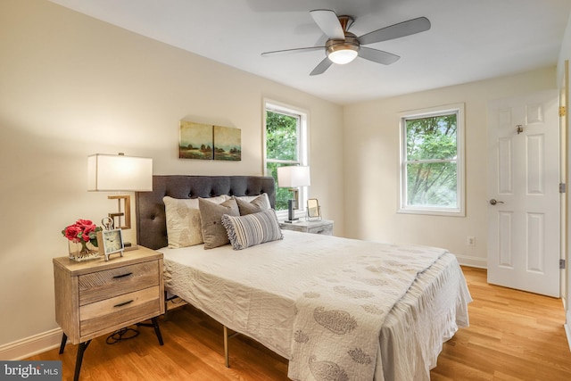 bedroom with light wood-type flooring, multiple windows, and ceiling fan