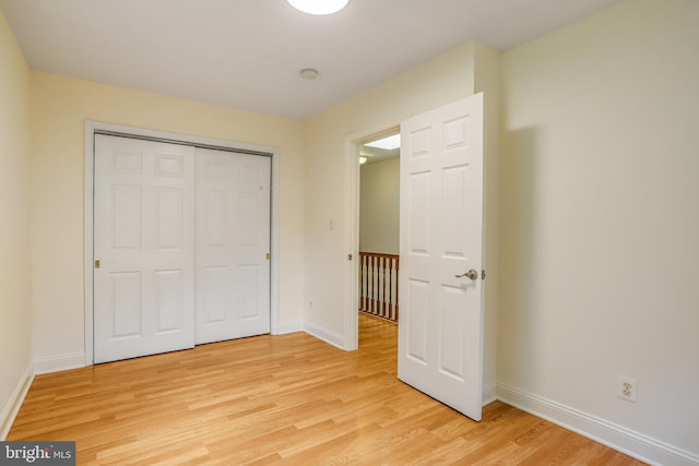 unfurnished bedroom with a closet and light wood-type flooring