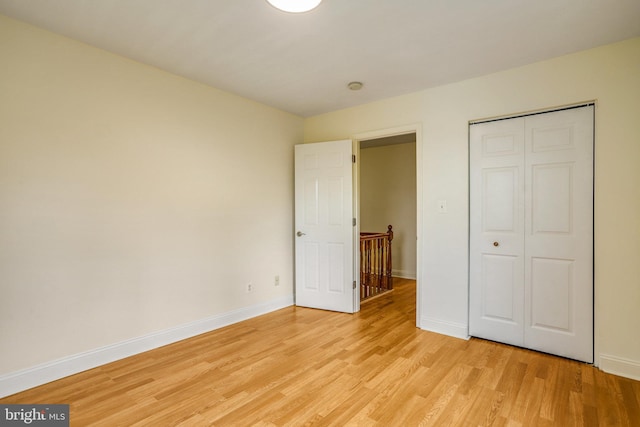 unfurnished bedroom with light hardwood / wood-style flooring and a closet