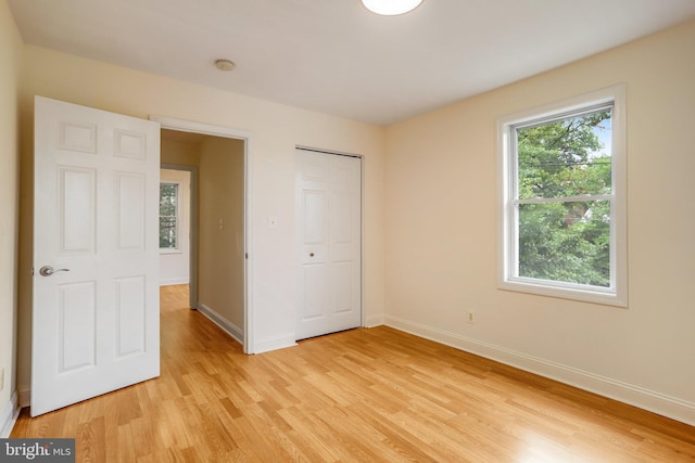 unfurnished bedroom with light hardwood / wood-style flooring and a closet