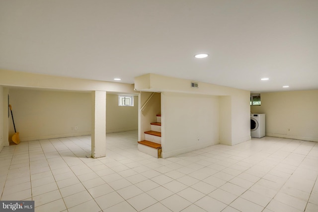 basement with washer / dryer and light tile patterned floors