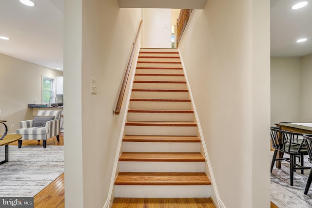 stairway with wood-type flooring and sink