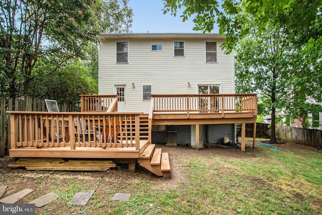 rear view of house featuring a lawn and a deck