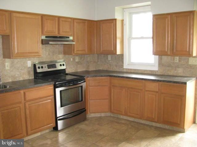 kitchen featuring sink, stainless steel electric range, and backsplash