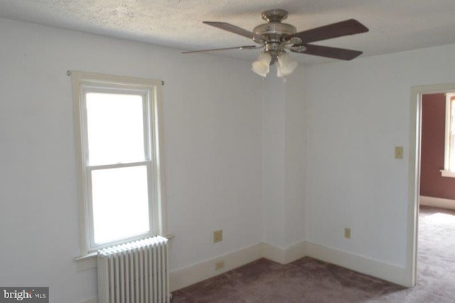 unfurnished room featuring radiator heating unit, a textured ceiling, ceiling fan, and carpet flooring