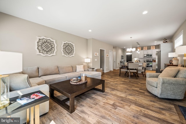 living room with a notable chandelier and hardwood / wood-style flooring