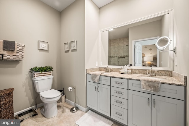 bathroom with tiled shower, vanity, toilet, and tile patterned floors