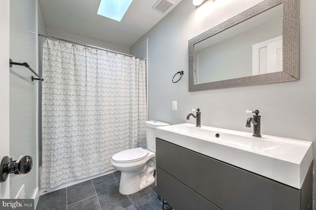 bathroom featuring a skylight, toilet, tile patterned floors, a shower with curtain, and vanity