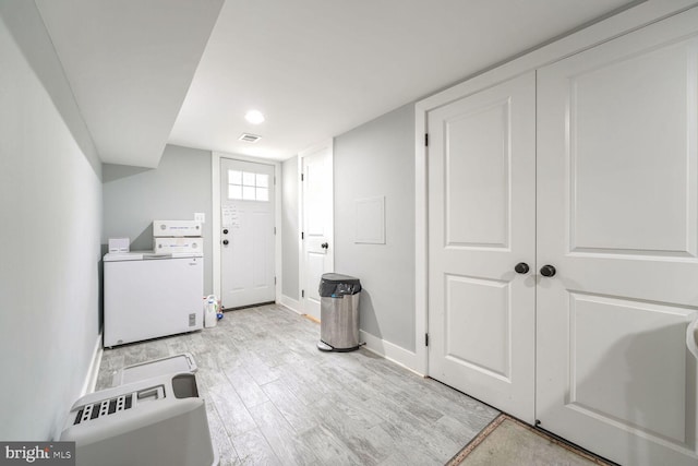 washroom with independent washer and dryer and light wood-type flooring