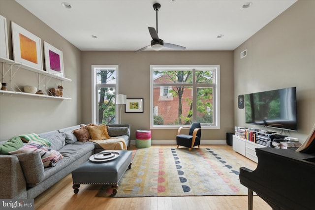 living room featuring plenty of natural light, ceiling fan, and light wood-type flooring