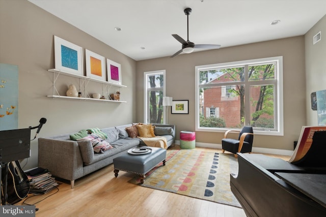 living room with ceiling fan and light hardwood / wood-style flooring