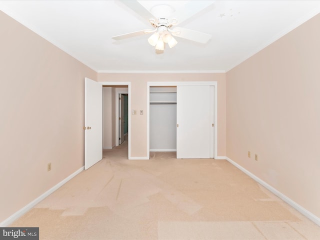 unfurnished bedroom with crown molding, a closet, ceiling fan, and carpet floors