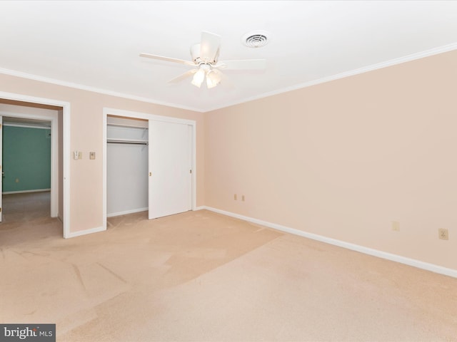 unfurnished bedroom featuring ceiling fan, crown molding, and light carpet