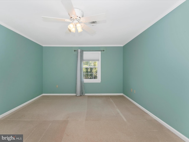 carpeted empty room featuring ceiling fan and crown molding