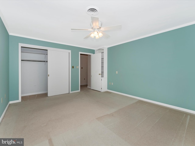 unfurnished bedroom with crown molding, a closet, ceiling fan, and carpet flooring