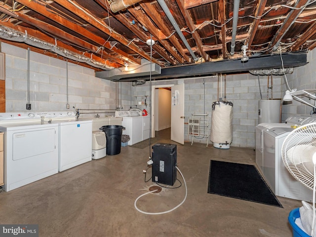 basement with electric water heater and washer and dryer