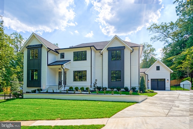 modern inspired farmhouse with an outdoor structure, a garage, and a front yard