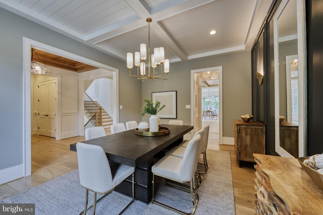 dining area featuring light wood-type flooring, coffered ceiling, beam ceiling, and a notable chandelier