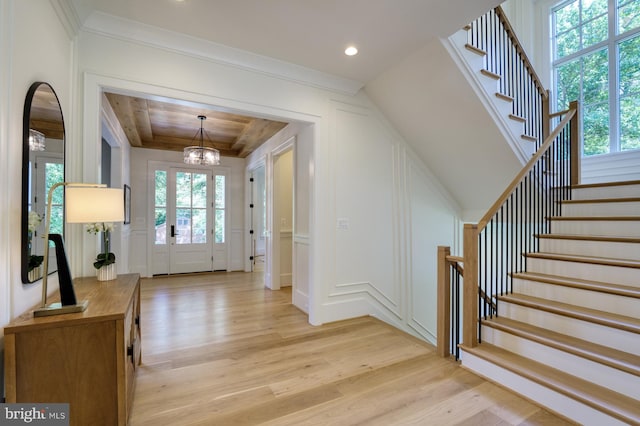 foyer with plenty of natural light, a chandelier, and light hardwood / wood-style flooring