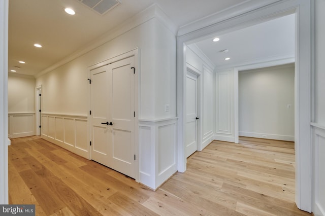 corridor with crown molding and light hardwood / wood-style floors