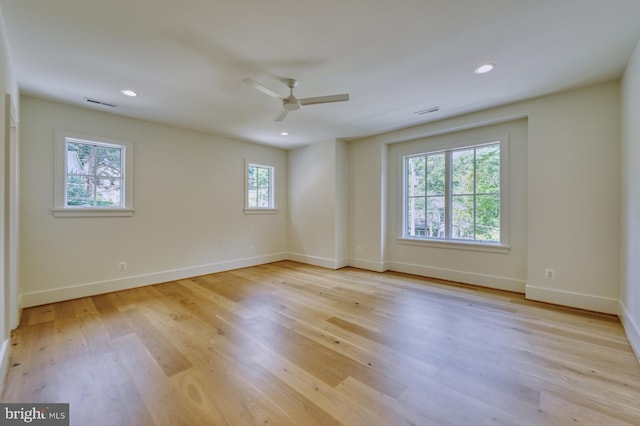 unfurnished room featuring a healthy amount of sunlight, ceiling fan, and light wood-type flooring