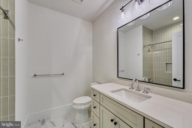 bathroom with tiled shower, toilet, and vanity