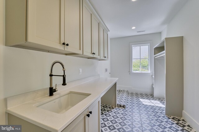 laundry room with cabinets and sink