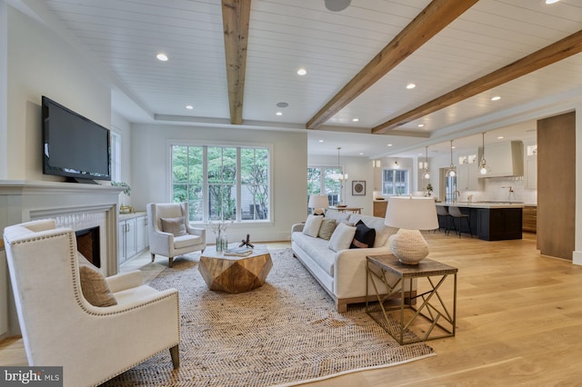 living room featuring beam ceiling and light hardwood / wood-style flooring