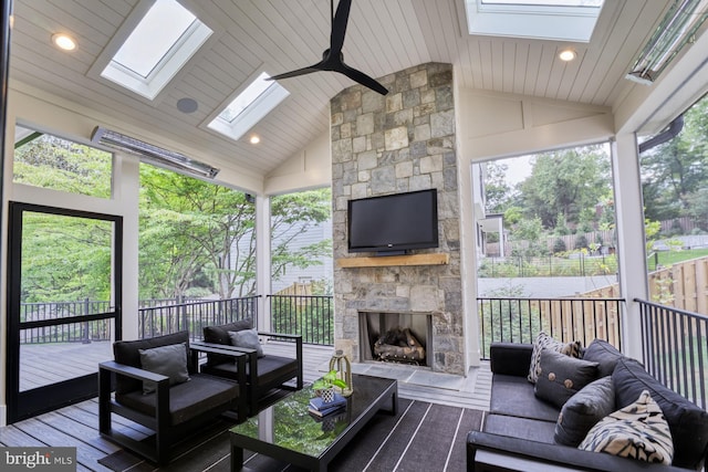 living room featuring a fireplace, a skylight, wood-type flooring, and a wealth of natural light