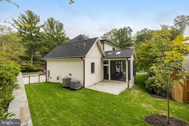 rear view of house with central air condition unit, a yard, and a patio