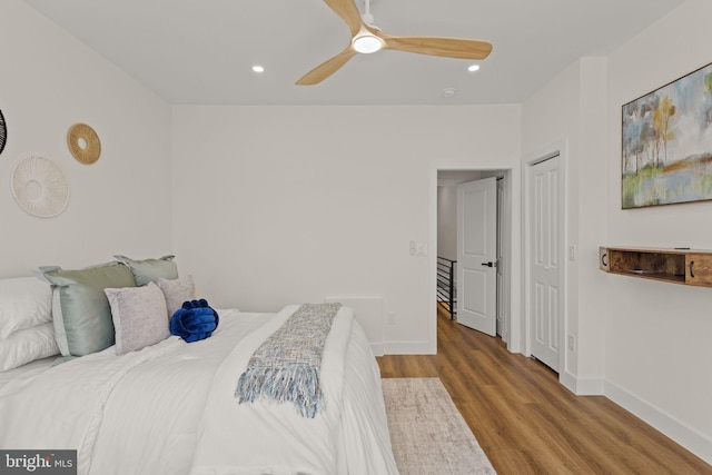 bedroom featuring ceiling fan, a closet, and hardwood / wood-style flooring