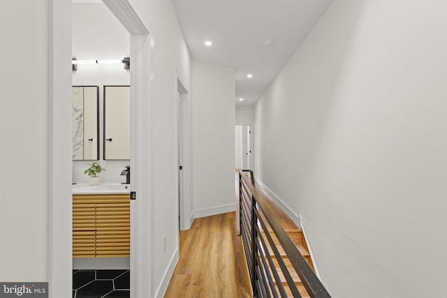 hall with light wood-type flooring and sink