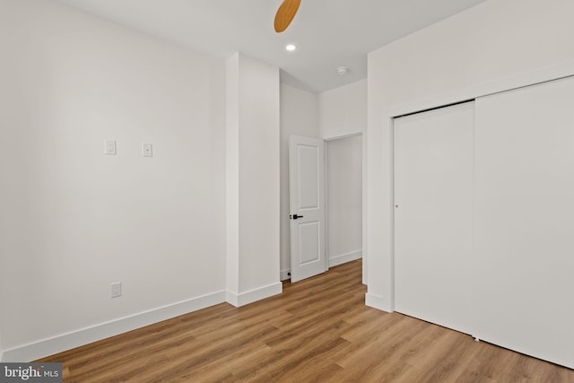 unfurnished bedroom featuring light wood-type flooring, a closet, and ceiling fan