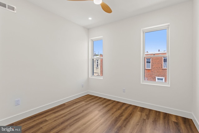 spare room featuring plenty of natural light, ceiling fan, and wood-type flooring